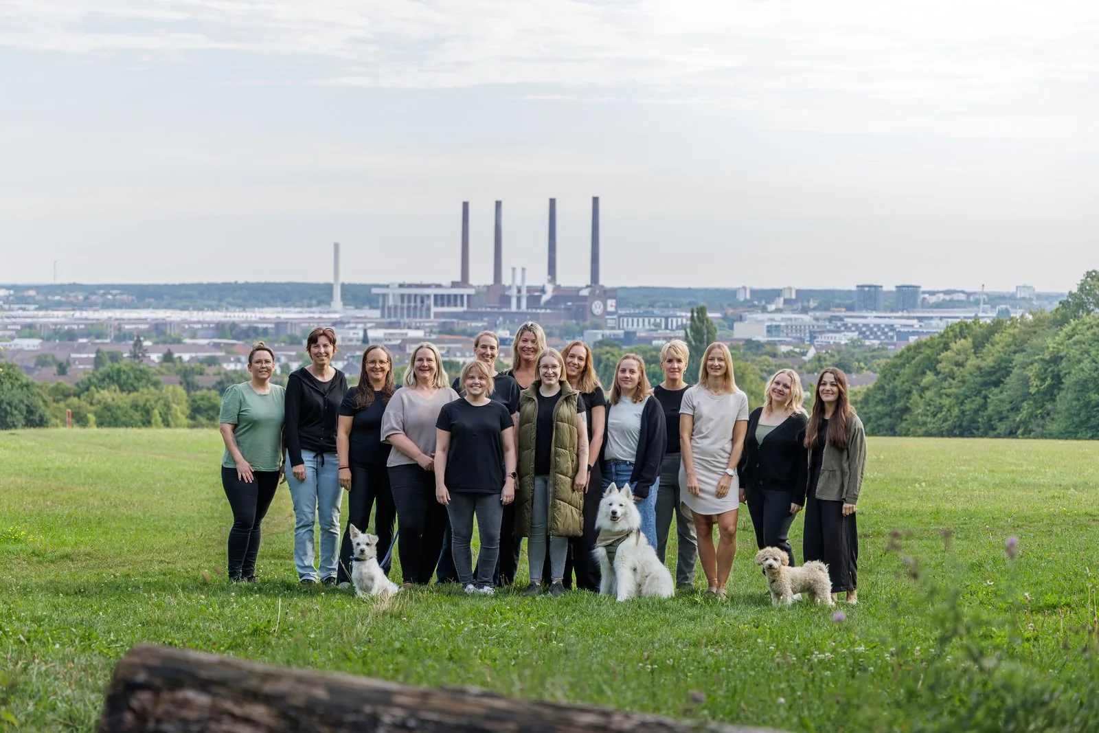 Das Team der Praxis ErgoLogo mit Bruno, Benni und Mali auf der Wiese über Wolfsburg